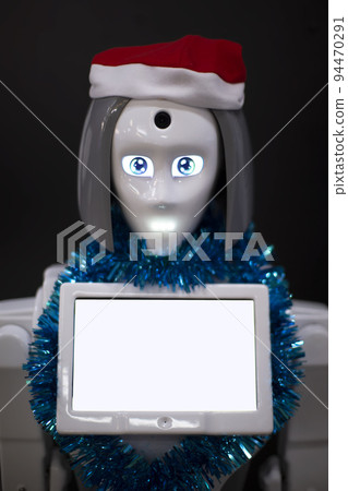 Robot with a blank information display in a Christmas hat close-up on a black background. Robot with a blank information display in a Christmas hat close-up on a black background. 94470291