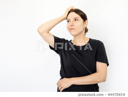 Portrait of young serious woman in black T-shirt looking up Portrait of young serious woman in black T-shirt looking up 94470919