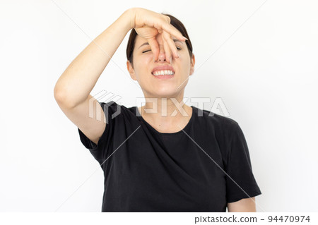 Portrait of young disgusted woman covering nose Portrait of young disgusted woman covering nose 94470974