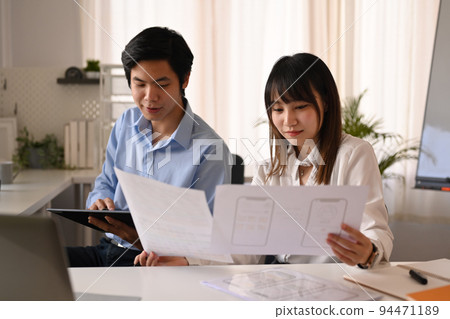 Developer team working on mobile application software design project together at modern corporate office Developer team working on mobile application software design project together at modern corporate office 94471189