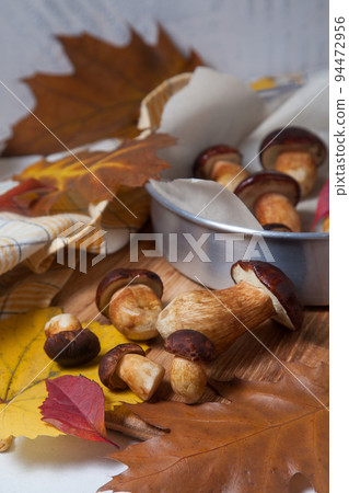 Several Imleria Badia or Boletus badius mushrooms commonly known as the bay bolete, vintage baking sheet with mushrooms on wooden cutting board.. Several Imleria Badia or Boletus badius mushrooms commonly known as the bay bolete, vintage baking sheet with mushrooms on wooden cutting board.. 94472956