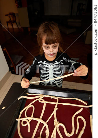 Boy child in skeleton costume preparing for halloween holiday 94473063