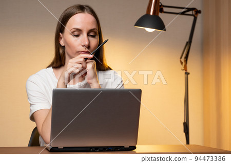 Female executive considering an employee's work schedule using a laptop 94473386