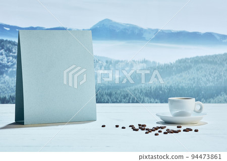 Cup of delicious coffee on snowy surface over mountain background 94473861