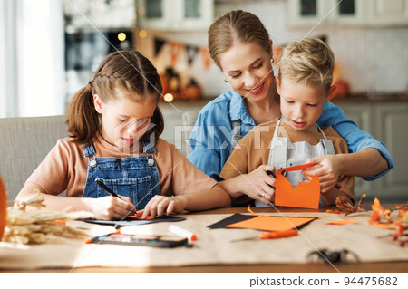 Young family mother and children preparing decorations for Halloween Young family mother and children preparing decorations for Halloween 94475682