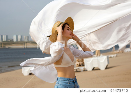 Caucasian girl on beach windy day Caucasian girl on beach windy day 94475740