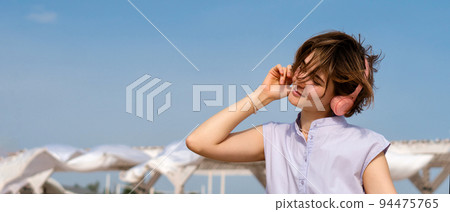 Girl listen to music in headphones outdoors 94475765