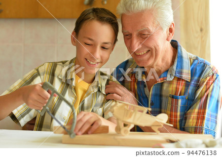 Grandfather and his grandson made an airplane model Grandfather and his grandson made an airplane model 94476138