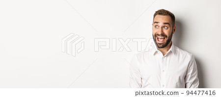 Close-up of happy and surprised man looking left with excitement, white background 94477416