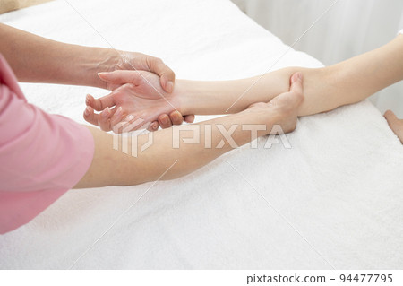 The hand of an esthetician who does a hand massage The hand of an esthetician who does a hand massage 94477795