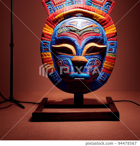 Peruvian Mayan Mask on stand in studio. Multi color. Ancient art. Studio Backdrop. Filmic lighting. Front light. Top light. Wooden floor. Directional lighting. 94478567