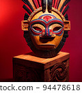 Peruvian Mayan Mask on stand in studio. Multi color. Ancient art. Studio Backdrop. Filmic lighting. Front light. Top light. Directional lighting. 94478618