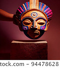 Peruvian Mayan Mask on stand in studio. Multi color. Ancient art. Studio Backdrop. Filmic lighting. Front light. Top light. Directional lighting. 94478628