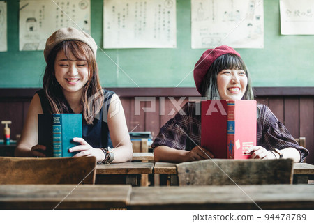 兩個女人看書玩得開心 兩個女人看書玩得開心 94478789