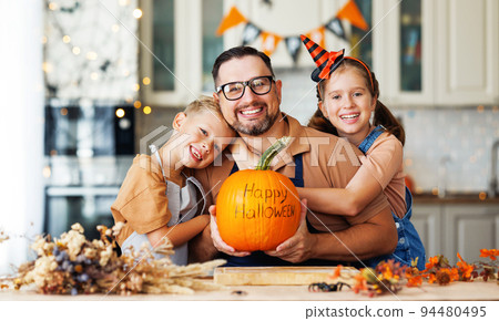 Happy family children hugging father with pumpkin with inscription Happy halloween 94480495