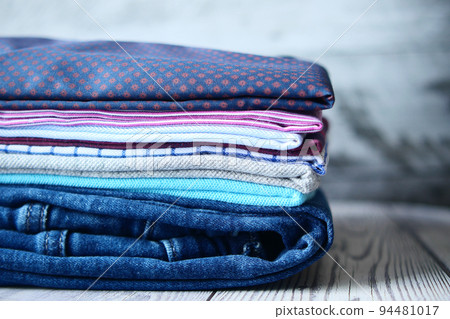 men hand putting shirts on table  94481017