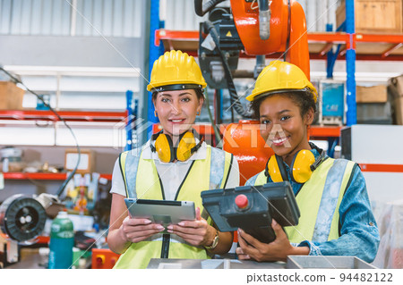 Women engineer worker working team training together at work in modern advanced robot welding machine factory. 94482122