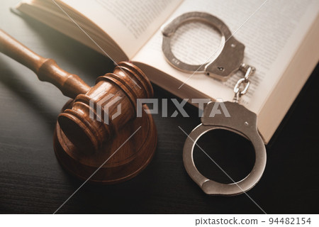 Arrest concept. Metal handcuffs near judge gavel Arrest concept. Metal handcuffs near judge gavel 94482154