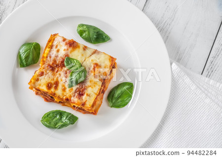 Portion of lasagne on white plate Portion of lasagne on white plate 94482284