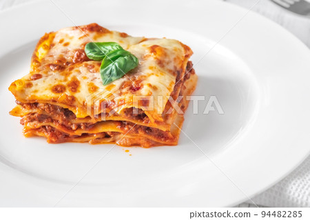 Portion of lasagne on white plate 94482285