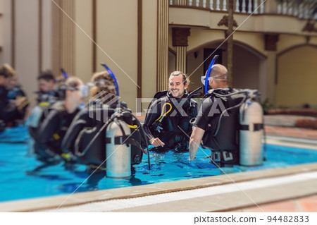 Diving instructor and students. Instructor teaches students to dive Diving instructor and students. Instructor teaches students to dive 94482833