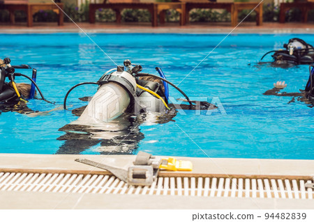 Diving instructor and students. Instructor teaches students to dive 94482839