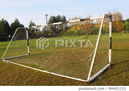 Old football goal against the background of the football field and autumn forest Old football goal against the background of the football field and autumn forest 94485235