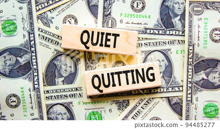 Quiet quitting symbol. Concept words Quiet quitting on wooden blocks. Beautiful background from dollar bills. Business and quiet quitting concept. Copy space. 94485277
