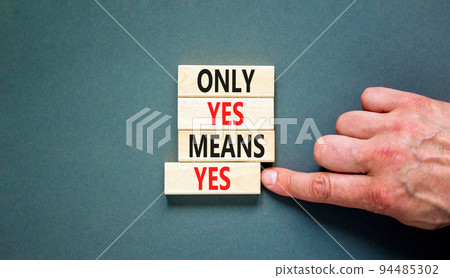 Only yes means yes symbol. Concept words Only yes means yes on wooden blocks on a beautiful grey table grey background. Businessman hand. Business, psychological only yes means yes concept. 94485302