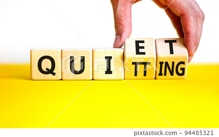Quiet quitting symbol. Concept words Quiet quitting on wooden cubes. Businessman hand. Beautiful yellow table white background. Business quiet quitting concept. Copy space. Quiet quitting symbol. Concept words Quiet quitting on wooden cubes. Businessman hand. Beautiful yellow table white background. Business quiet quitting concept. Copy space. 94485321