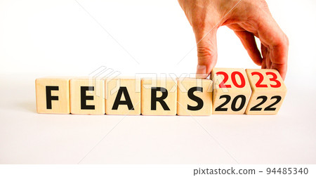 2023 fears new year symbol. Businessman turns a wooden cube and changes words Fears 2022 to Fears 2023. Beautiful white table white background, copy space. Business 2023 fears new year concept. 2023 fears new year symbol. Businessman turns a wooden cube and changes words Fears 2022 to Fears 2023. Beautiful white table white background, copy space. Business 2023 fears new year concept. 94485340