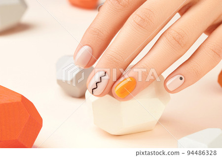 Manicured womans hand close up on beige background. Minimal spring autumn nail design 94486328