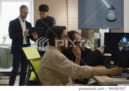 Artists of company for 3D development of games emotionally discussing project Artists of company for 3D development of games emotionally discussing project 94486567