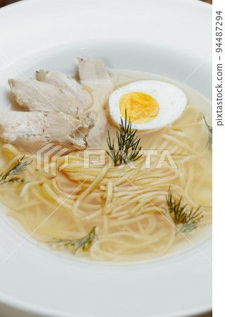 Chicken soup with noodles and vegetables in white bowl Chicken soup with noodles and vegetables in white bowl 94487294