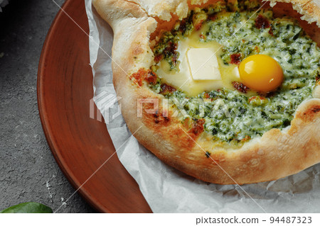 Some khachapuri traditional Georgian homemade cheese and spinach pies on the plate Some khachapuri traditional Georgian homemade cheese and spinach pies on the plate 94487323