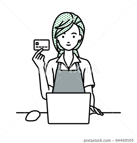 A female clerk sitting at a desk and using a PC while holding a credit card 94489505