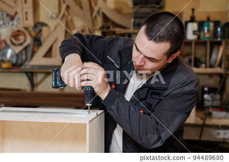 Man Building Wooden Furniture 94489680