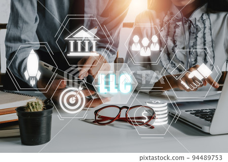 Limited Liability Company (LLC) Business Concept, Business team analyzing data and using tablet on desk with limited liability company icon on Vr screen. Limited Liability Company (LLC) Business Concept, Business team analyzing data and using tablet on desk with limited liability company icon on Vr screen. 94489753