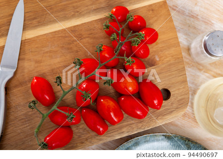 Fresh cherry tomatoes ready for cooking on table Fresh cherry tomatoes ready for cooking on table 94490697