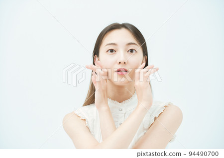A woman checking the condition of her skin A woman checking the condition of her skin 94490700