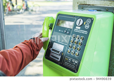 拿著公用電話聽筒的女人的手 94490839
