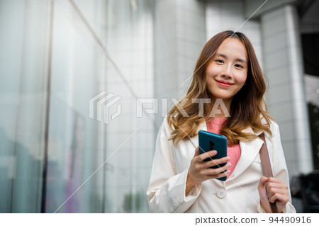 Asian businesswoman texting smartphone commuting work Asian businesswoman texting smartphone commuting work 94490916
