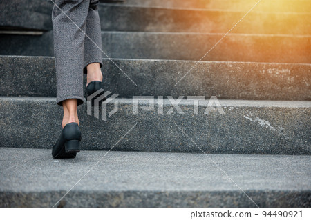Closeup legs of businesswoman hurry up walking on stairway 94490921