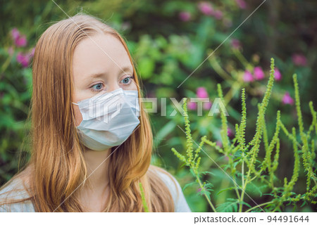 Young woman in a medical mask because of an allergy to ragweed Young woman in a medical mask because of an allergy to ragweed 94491644