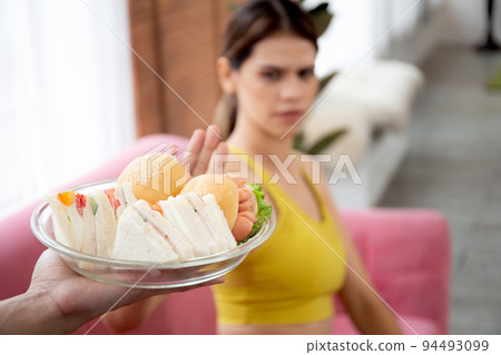 Hands serving food and young caucasian woman making sign say no food unhealthy with obese. Hands serving food and young caucasian woman making sign say no food unhealthy with obese. 94493099