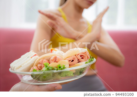 Hands serving food and young caucasian woman making sign say no food unhealthy with obese. Hands serving food and young caucasian woman making sign say no food unhealthy with obese. 94493100