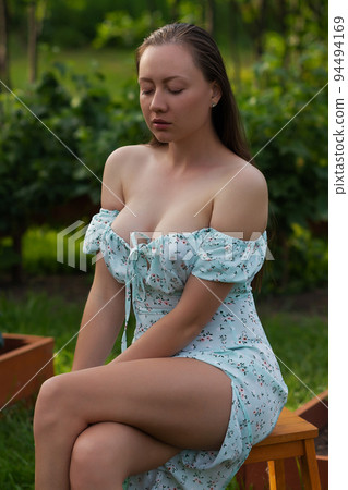 Sensitive woman sitting in garden 94494169