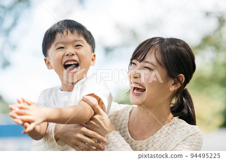 Smiling boy playing in the park and mother/child-rearing image Smiling boy playing in the park and mother/child-rearing image 94495225