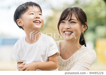 Smiling boy playing in the park and mother/child-rearing image 94495228