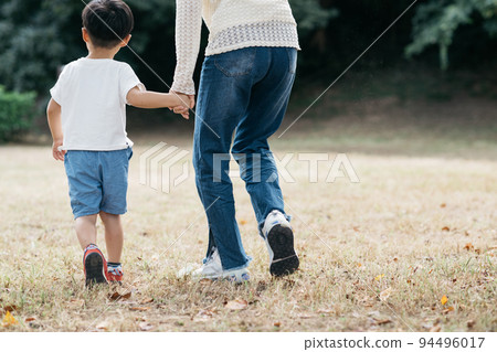 父母和孩子在公園裡散步的背影/度假時的家庭形象 94496017